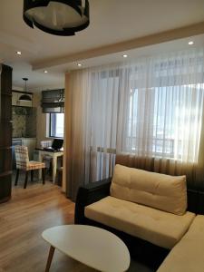 ein Wohnzimmer mit einem Sofa und einem Tisch in der Unterkunft Апартамент Легал in Tschepelare