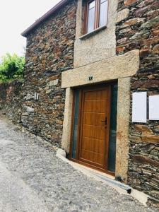 una puerta de madera en el lateral de un edificio de piedra en "Casa do Avô Armindo" Mountain Experience en Vila Real