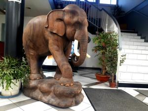 a statue of an elephant standing on a rock at Apparthotel AREA, Studios avec salle de bain et kitchenette Privées, OU, chambres avec salles bain et cuisines communes in Persan