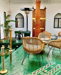 um quarto com cadeiras de vime e uma mesa de vidro em Riad Dar Yasaman em Marraquexe