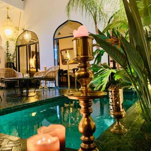 um quarto com uma piscina com uma mesa e um espelho em Riad Dar Yasaman em Marraquexe