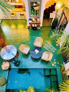 an overhead view of a pool with tables and chairs at Riad Dar Yasaman in Marrakesh