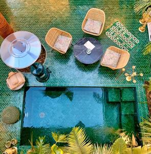 - une vue sur une table, des chaises et une piscine d'eau dans l'établissement Riad Dar Yasaman, à Marrakech