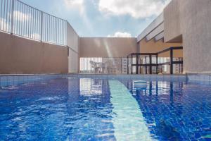 a swimming pool in front of a building at Guará Inn Flat Service in Guaratinguetá