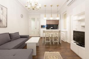 ein Wohnzimmer mit einem Sofa und einem Tisch in der Unterkunft Belgrade Center Apartment Slavija Square II in Belgrad