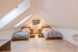 a attic bedroom with two beds and a staircase at Varoš apartment in Split