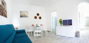 sala de estar con sofá azul y mesa en L'Ancora Holidays, en Punta Secca