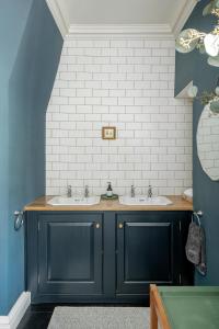 a bathroom with two sinks and blue cabinets at Superior Stays Rosewell House - Bath City Centre in Bath