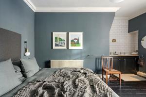 a bedroom with blue walls and a bed and a desk at Superior Stays Rosewell House - Bath City Centre in Bath