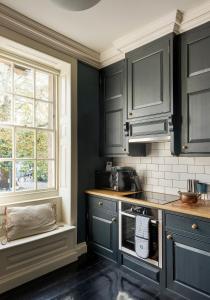 a kitchen with dark blue cabinets and a window at Superior Stays Rosewell House - Bath City Centre in Bath +65 photos