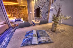 a book on a table with a vase on it at Matrix Apartments Hrebienok in Vysoke Tatry - Stary Smokovec