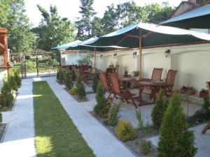 une terrasse avec une table, des chaises et un parasol dans l'établissement Tzvetelina Palace Hotel, à Dolna Banya