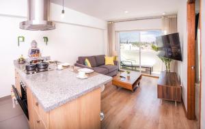 cocina y sala de estar con sofá y mesa en Resort Style Condo near heart of AQP - Gym, Pool & Netflix, en Arequipa