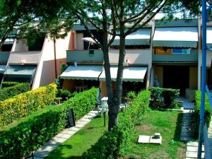 a building with a tree in front of a building at Rio Piccolo Apartment in Principina a Mare