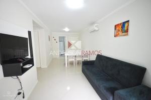 sala de estar con sofá negro y TV en 1016 - Locação de Temporada em Bombinhas - Residencial Alameda Verde Apto 103, en Bombinhas