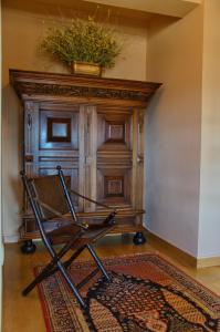 krzesło przed drewnianą ścianą z rośliną w obiekcie Levandes Houses w Kalawricie