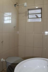 a bathroom with a bath tub and a window at Hotel Ragueb in Sao Paulo