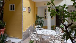 a table and chairs in front of a yellow building at Pequeno Gran Hotel in Aguascalientes