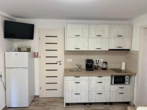 a kitchen with white cabinets and a white refrigerator at Smiley Rezident in Sibiu