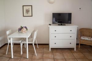 - une table à manger blanche avec une télévision et une commode dans l'établissement Casas de Campo do Pomar B&B - Self Check-in, à Santana