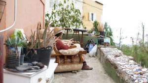 a man sitting on a chair with a baby at Camino Art House in Vega de San Mateo