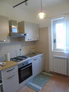 a kitchen with a stove and a sink and a window at il pettirosso in Altino