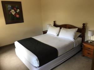a neatly made bed in a small room at Seacombe House Motor Inn Port Fairy in Port Fairy