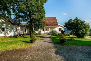a house with a gravel driveway in front of it at Lysefjorden - Gøysa Gard in Forsand
