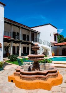 une fontaine au milieu d'une cour avec un bâtiment dans l'établissement Hotel Casa del Agua, à Tuxtla Gutiérrez