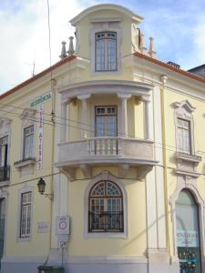 un edificio giallo con un balcone sopra di Guesthouse Lusa Atenas a Coimbra