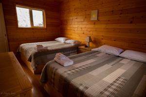 a room with two beds in a log cabin at Sundog Retreat in Whitehorse