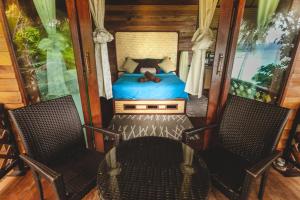 1 Schlafzimmer mit einem Bett, 2 Stühlen und einem Tisch in der Unterkunft Bayview Hill Resort in Ko Lipe
