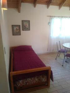 1 dormitorio con 1 cama, mesa y sillas en Departamento Laguna Blanca en San Carlos de Bariloche