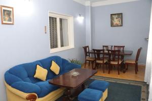 een woonkamer met een blauwe bank en een tafel bij Апартаменты 100м2 в малом центре Еревана in Jerevan