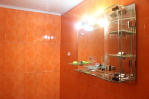 a bathroom with orange tiles and a mirror at Уютные апартаменты в малом центре Еревана in Yerevan