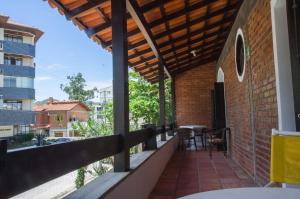 un balcón de una casa con mesa y sillas en pousada bella canas, en Florianópolis