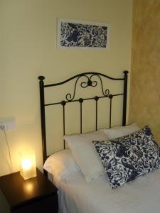 Una cama con una almohada y una lámpara sobre una mesa. en PR Tambre, en Santiago de Compostela