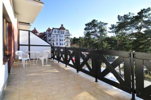 - Balcón con mesa y sillas en un edificio en Hotel Continental, en Krynica Morska