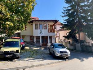 two cars parked in front of a house at Villa La in Sarajevo