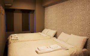 a bed room with a white bedspread and pillows at Uno Ueno in Tokyo