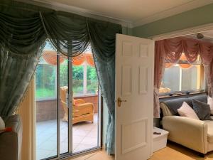 a living room with a large window and a couch at Beautiful and Peaceful village location in Bishop's Wood