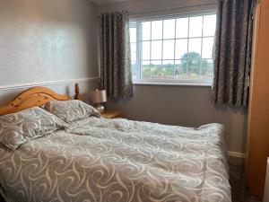 - un lit dans une chambre avec fenêtre dans l'établissement Beautiful and Peaceful village location, à Bishop's Wood
