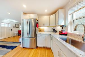 a kitchen with white cabinets and a stainless steel refrigerator at Summer Sun in Provincetown