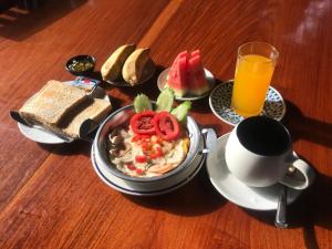 uma mesa com uma tigela de comida e uma chávena de sumo de laranja em Pai Loess Resort em Pai