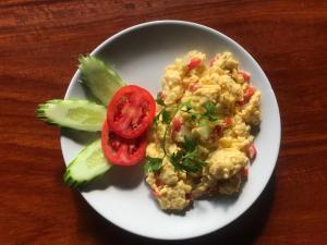 a white plate with eggs and vegetables on a table at Pai Loess Resort in Pai