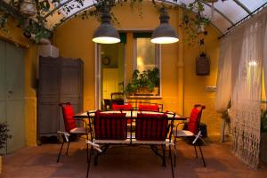 a dining room with a table and red chairs at Siwa Home Experience in Anzio