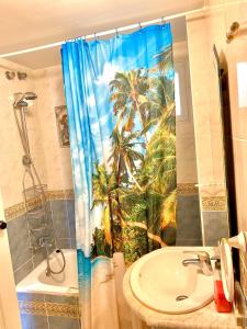 a bathroom with a shower curtain with palm trees at JP - 3.0 in Benalmádena