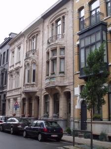 un gran edificio con coches estacionados frente a él en Apartments Suites in Antwerp, en Amberes
