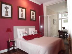 sypialnia z czerwonymi ścianami i łóżkiem z czerwonymi poduszkami w obiekcie Apartments Suites in Antwerp w Antwerpii