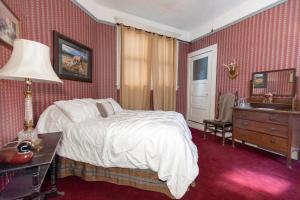 a bedroom with a bed and a table with a lamp at Bisbee Grand Hotel in Bisbee